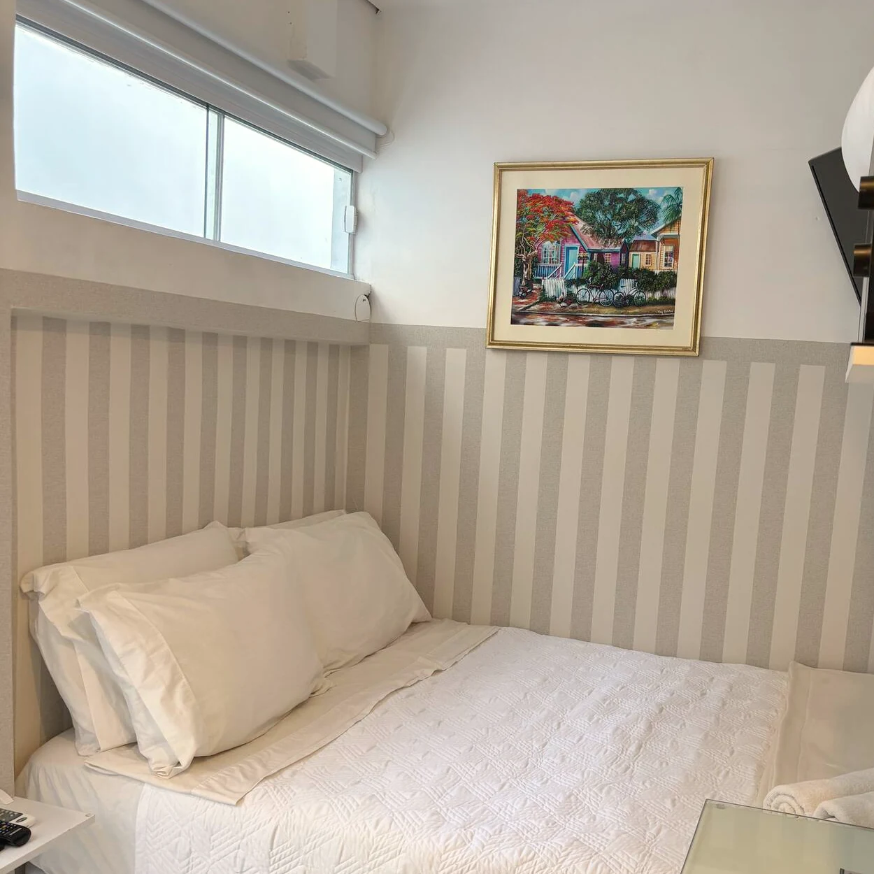 Monoambiente económico con cama doble y cabecera de rayas